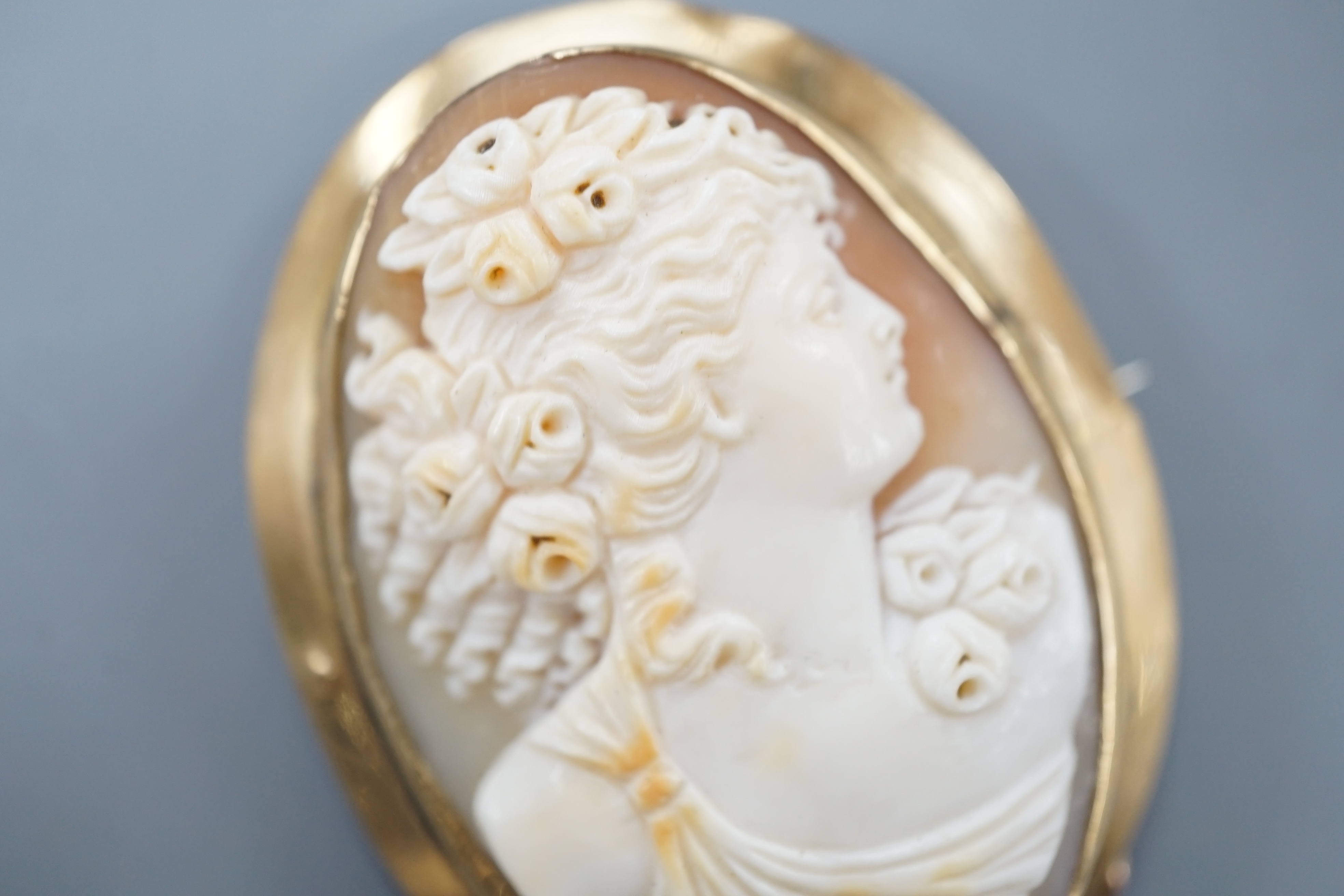 A yellow metal mounted oval cameo shell brooch, carved with the bust of a lady to sinister, 51mm, gross 16 grams.